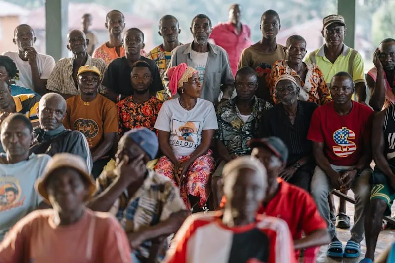 Community members sitting together at an outdoor gathering in Africa