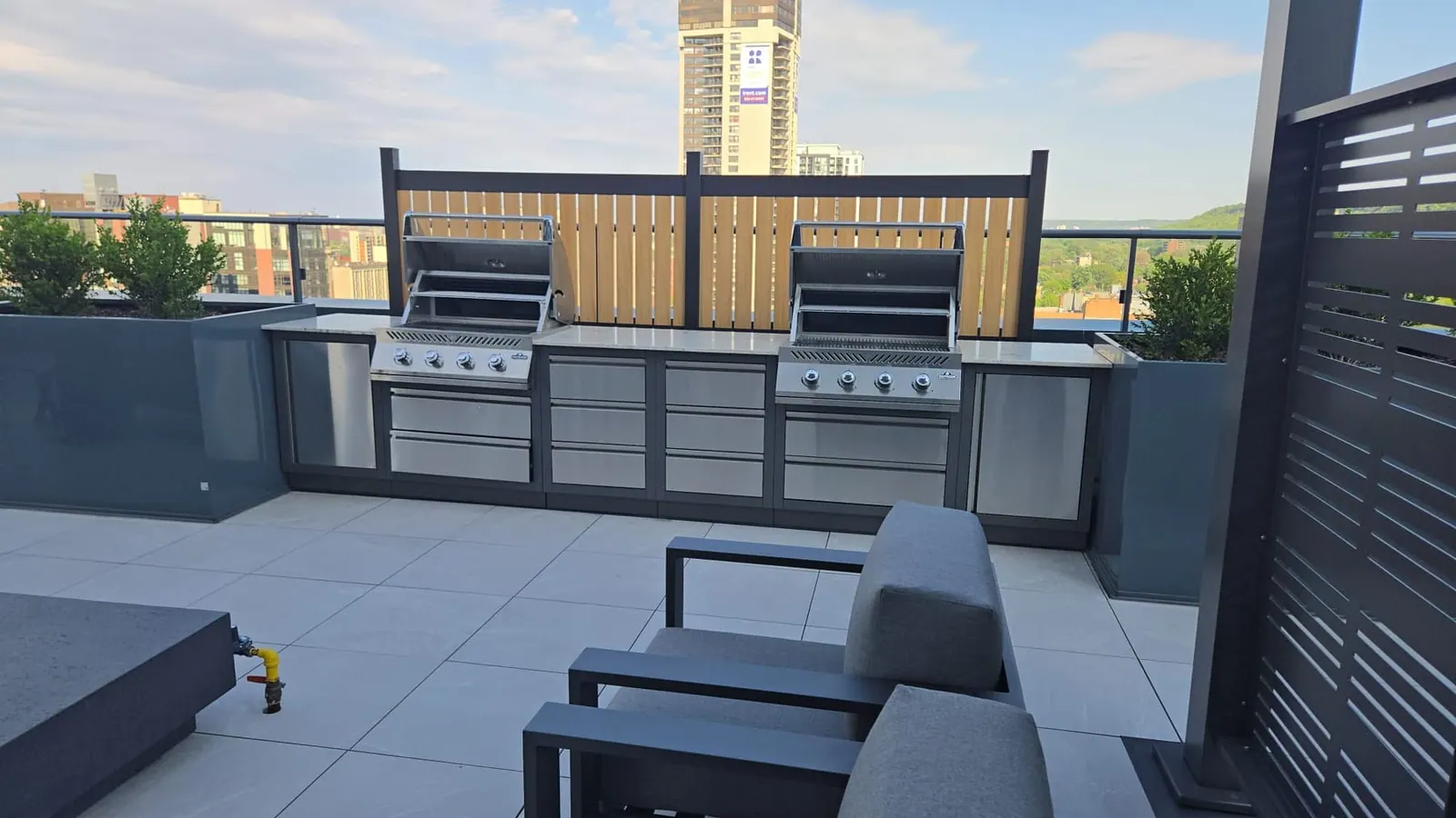 Stainless-steel barbecue grills on the rooftop in warm late-afternoon light