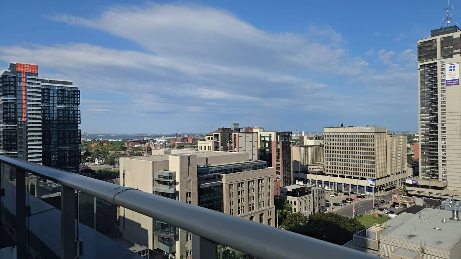 Panoramic rooftop view of a dense downtown skyline under dramatic billowing white clouds.