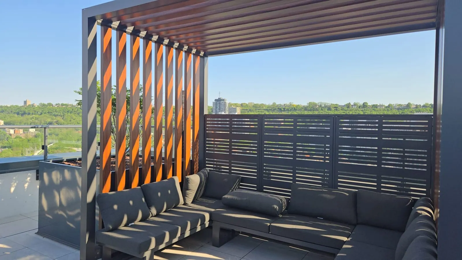 Warm orange-timber pergola slats casting diagonal shadows across the rooftop seating area.